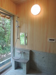 桧と十和田石が使われている浴室。洗面器置き台の天板には御影石。外の景色を眺めながら入ることができるお風呂は、心も身体も癒してくれます。