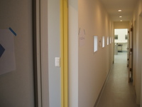黄色い引戸の枠がよく映える白い壁。長い長い廊下には、５つのLIXIL（リクシル）製の小窓たちが外の光りをもたらしてくれます。
